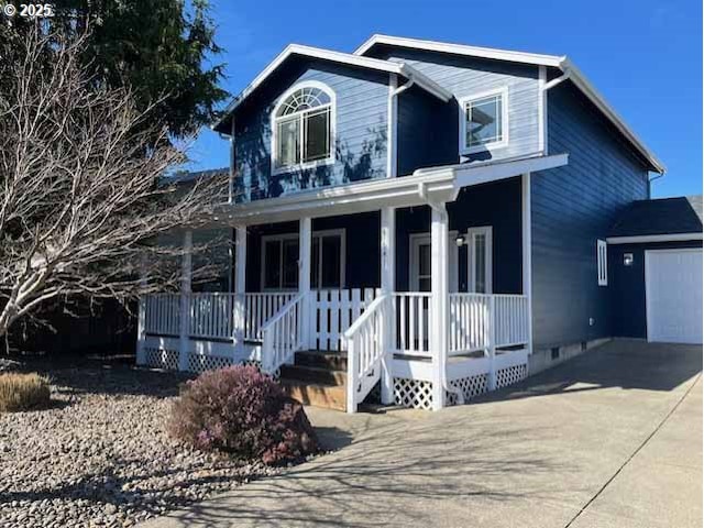 traditional home with covered porch, driveway, an outdoor structure, and a garage