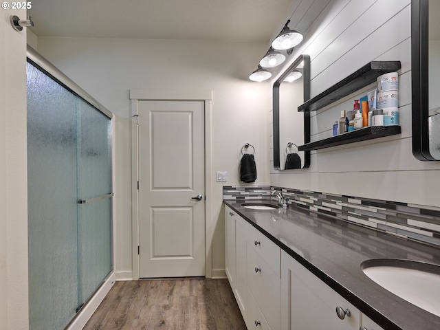 bathroom with vanity, an enclosed shower, hardwood / wood-style floors, and backsplash