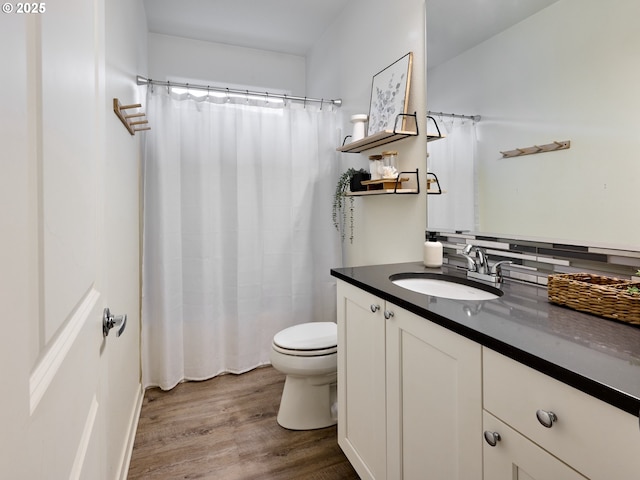 bathroom featuring toilet, vanity, wood finished floors, and a shower with curtain