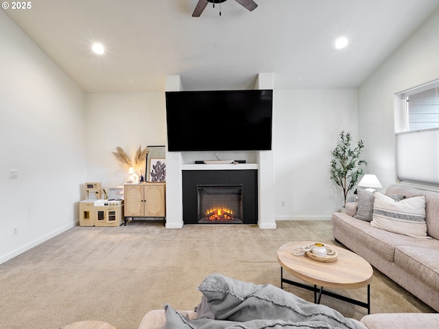 living room featuring ceiling fan, light colored carpet, and a tile fireplace