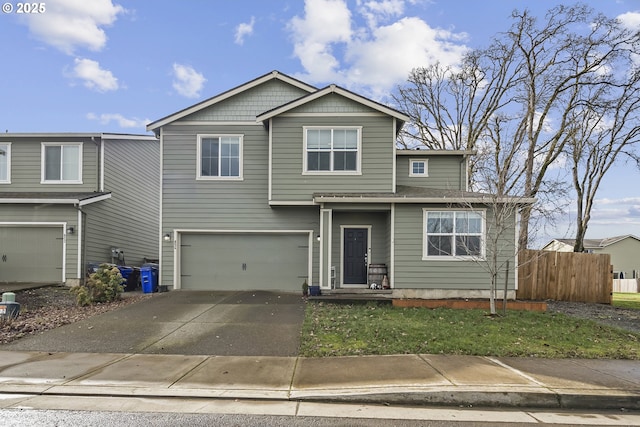 view of front of property with concrete driveway, a garage, and fence