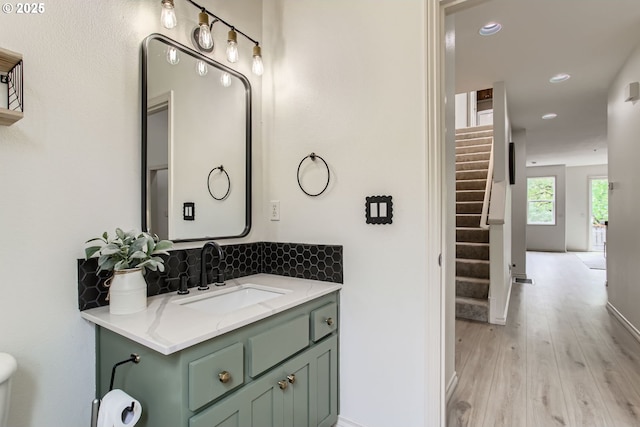 10372 NW Forestview Way, Portland, OR 97229 - bathroom with wood finished floors, backsplash, vanity, recessed lighting, and baseboards