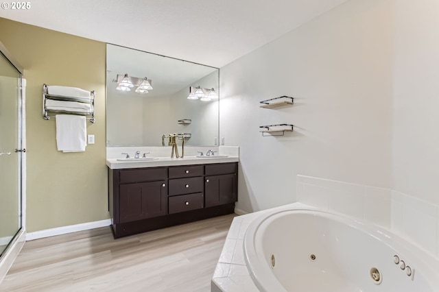 10372 NW Forestview Way, Portland, OR 97229 - bathroom with a jetted tub, double vanity, wood finished floors, and baseboards
