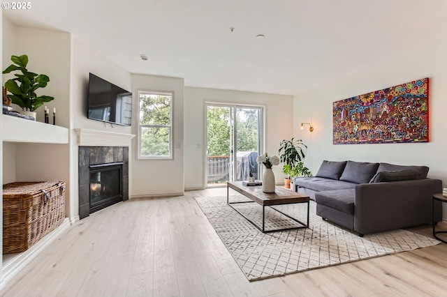 10372 NW Forestview Way, Portland, OR 97229 - living room featuring wood finished floors, a tiled fireplace, and baseboards