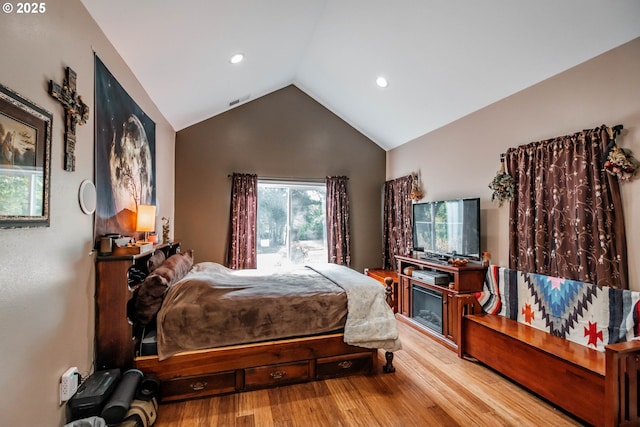 bedroom with lofted ceiling and light hardwood / wood-style flooring