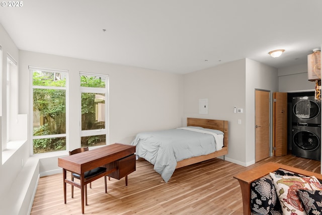 2021 SE Clinton St Unit 103, Portland, OR 97202 - bedroom featuring stacked washing machine and dryer and light wood finished floors