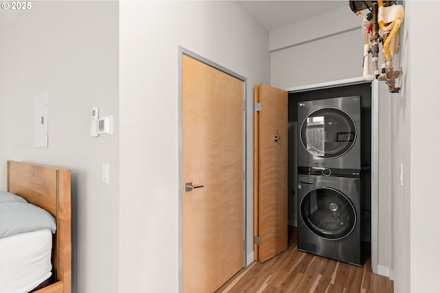 2021 SE Clinton St Unit 103, Portland, OR 97202 - laundry room featuring stacked washer and clothes dryer, light wood-style floors, and electric panel