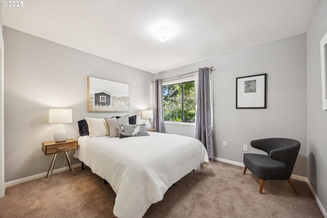 bedroom with light colored carpet and baseboards