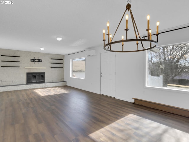 unfurnished living room featuring a fireplace, a wall mounted AC, a baseboard heating unit, wood finished floors, and baseboards