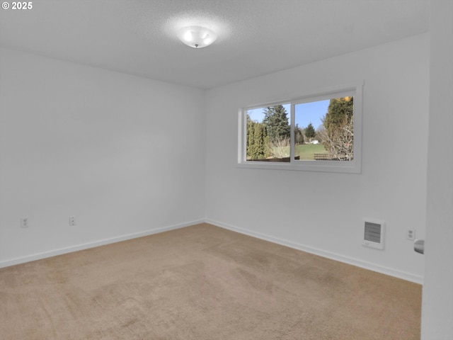 empty room with carpet floors, baseboards, visible vents, and a textured ceiling