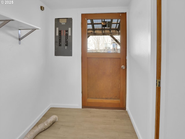 doorway to outside with light wood-style floors, electric panel, and baseboards