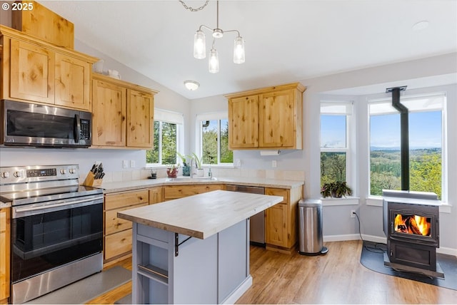 21600 NE Forest Dr, Yamhill, OR 97148 - kitchen featuring stainless steel appliances, a wood stove, a sink, vaulted ceiling, and light countertops