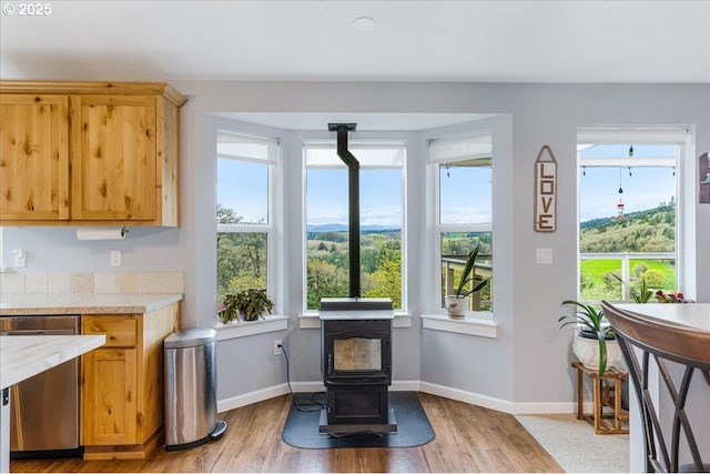 21600 NE Forest Dr, Yamhill, OR 97148 - dining room with a wood stove, light wood-type flooring, and baseboards