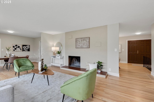 living room with light wood-type flooring and a fireplace