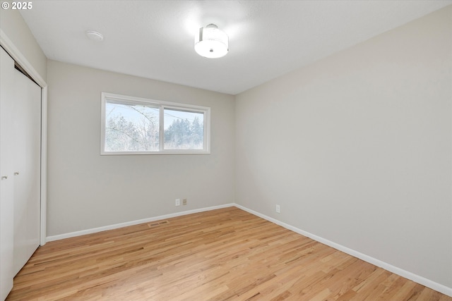 unfurnished bedroom featuring light hardwood / wood-style flooring and a closet