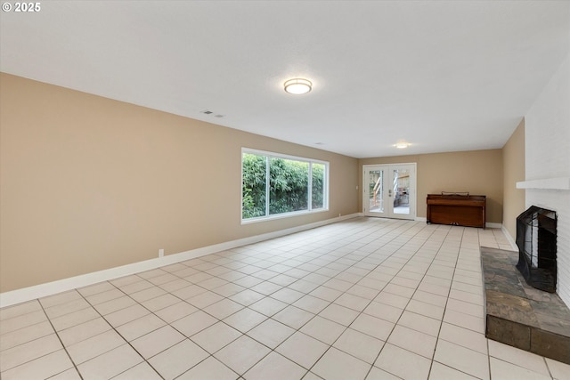 unfurnished living room featuring light tile patterned floors, a fireplace, and french doors