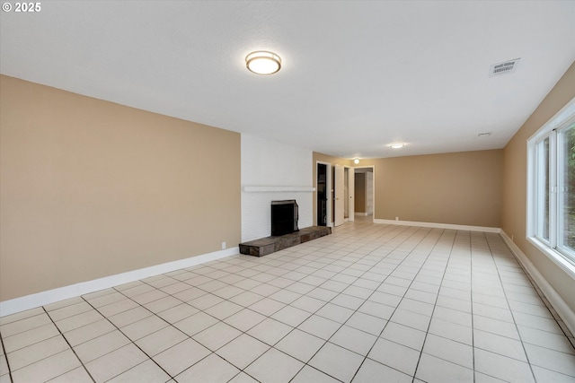 unfurnished living room featuring a fireplace and light tile patterned floors