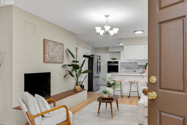 living room featuring a chandelier and light wood-type flooring