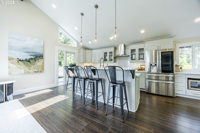 32518 Dillard Rd, Eugene, OR 97405 - kitchen featuring appliances with stainless steel finishes, wall chimney exhaust hood, healthy amount of natural light, a breakfast bar area, and recessed lighting