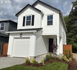 view of front of property featuring board and batten siding, an attached garage, driveway, and fence