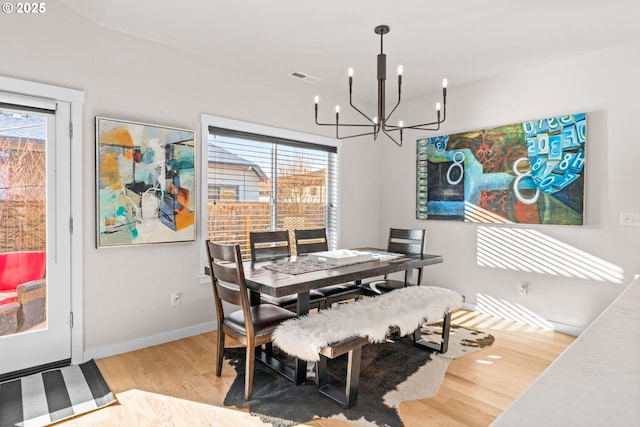 dining area featuring a notable chandelier and light wood-type flooring