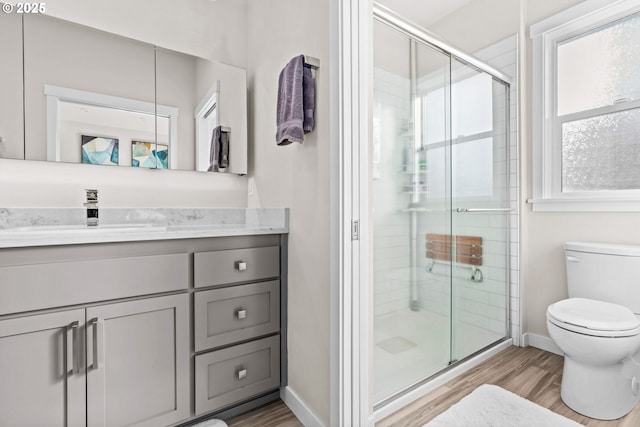 bathroom featuring vanity, wood-type flooring, toilet, and walk in shower