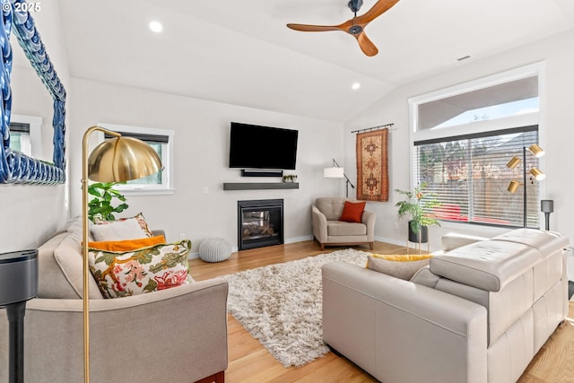 living room with ceiling fan, lofted ceiling, and light hardwood / wood-style floors