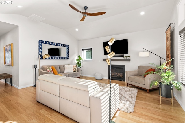 living room featuring ceiling fan, vaulted ceiling, and light hardwood / wood-style flooring