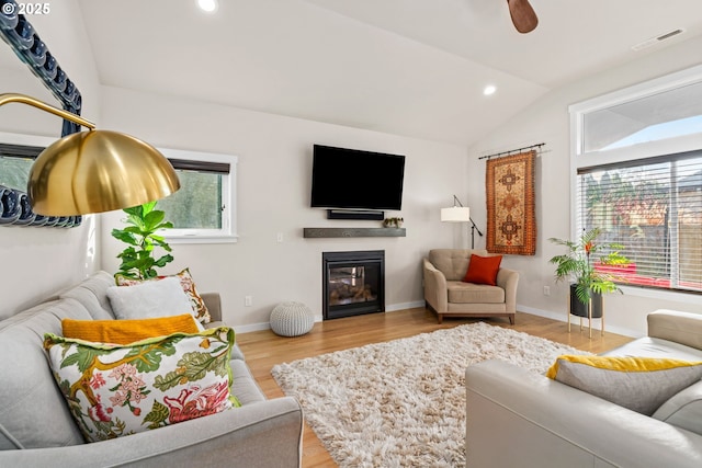 living room with lofted ceiling, ceiling fan, and light hardwood / wood-style flooring