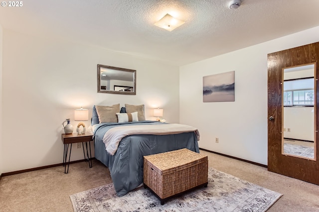 bedroom with light carpet, a textured ceiling, and baseboards