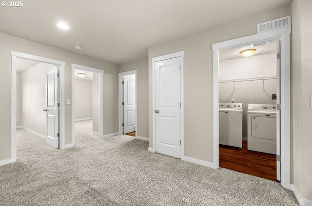 clothes washing area featuring carpet flooring, laundry area, visible vents, and washing machine and clothes dryer