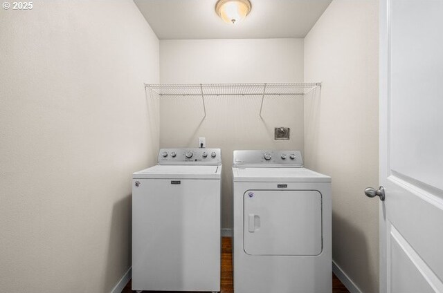 clothes washing area featuring laundry area, washing machine and dryer, and baseboards