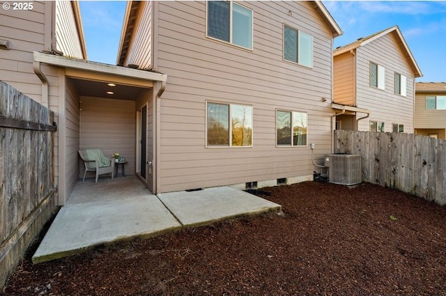 rear view of property featuring central AC unit, a patio area, and fence