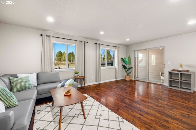 living area with baseboards, wood finished floors, and recessed lighting