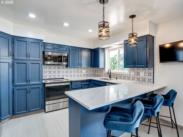 5210 N Emerson Dr, Portland, OR 97217 - kitchen featuring stainless steel appliances, blue cabinets, a peninsula, a breakfast bar area, and recessed lighting