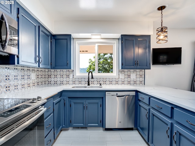 5210 N Emerson Dr, Portland, OR 97217 - kitchen featuring stainless steel appliances, a sink, backsplash, and blue cabinetry
