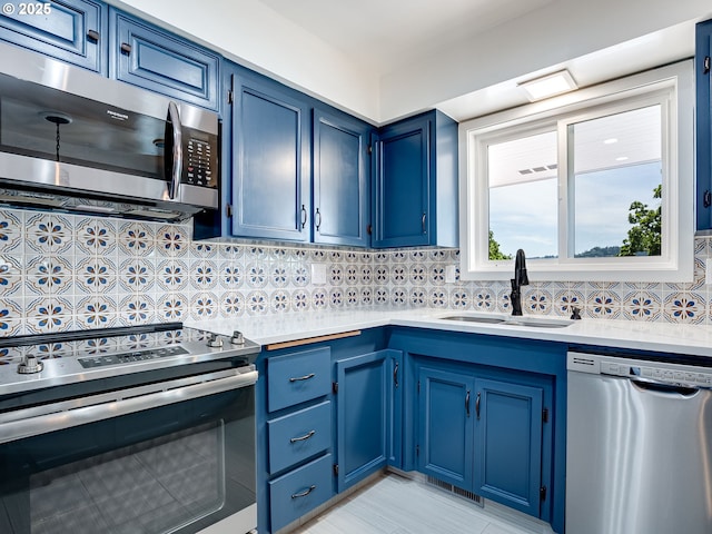 5210 N Emerson Dr, Portland, OR 97217 - kitchen with appliances with stainless steel finishes, a sink, blue cabinets, and light countertops