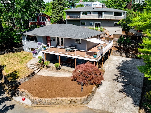 5210 N Emerson Dr, Portland, OR 97217 - rear view of house featuring driveway, stairway, a shingled roof, a deck, and outdoor dining area