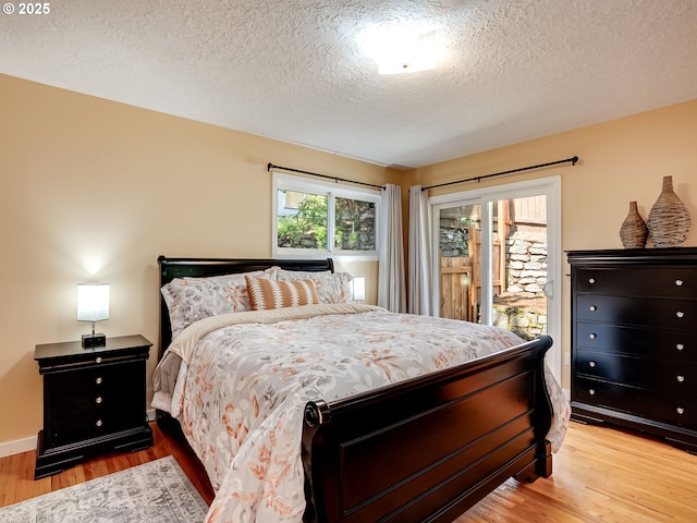 5210 N Emerson Dr, Portland, OR 97217 - bedroom with light wood-type flooring, access to exterior, and a textured ceiling