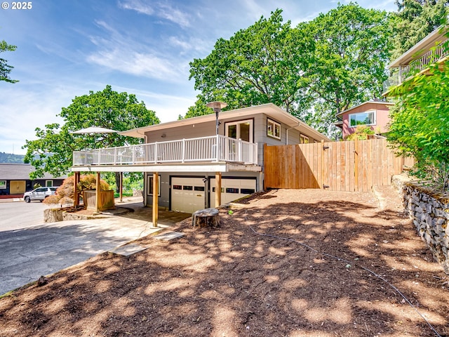 5210 N Emerson Dr, Portland, OR 97217 - view of front facade featuring driveway, an attached garage, and a wooden deck