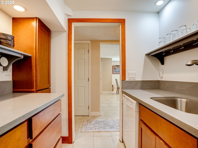5210 N Emerson Dr, Portland, OR 97217 - kitchen with white dishwasher, light tile patterned floors, recessed lighting, light countertops, and brown cabinetry