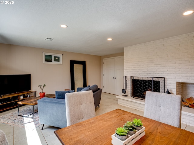 5210 N Emerson Dr, Portland, OR 97217 - living room featuring light tile patterned flooring, a brick fireplace, recessed lighting, and a textured ceiling