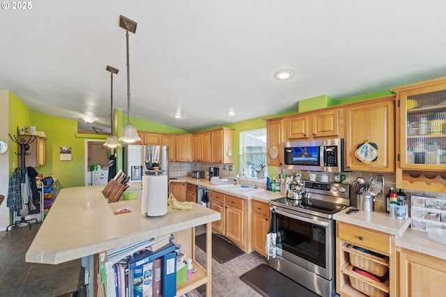 kitchen with appliances with stainless steel finishes, pendant lighting, tasteful backsplash, lofted ceiling, and sink