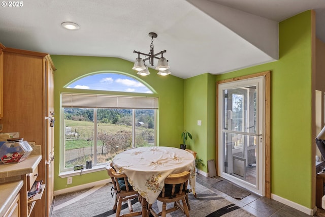 dining area featuring vaulted ceiling, a chandelier, and a healthy amount of sunlight