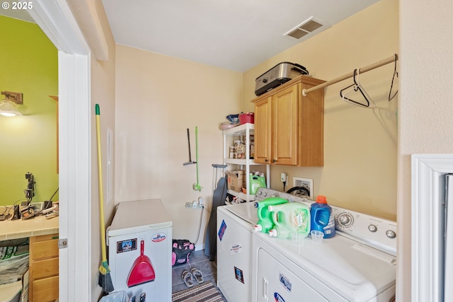 laundry area with washing machine and dryer and cabinets