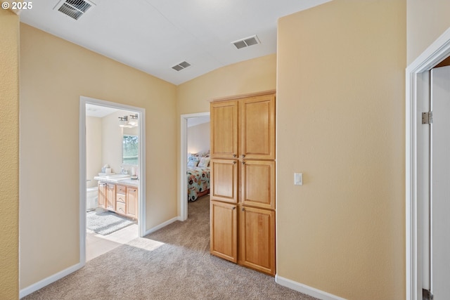 hall featuring light carpet and vaulted ceiling