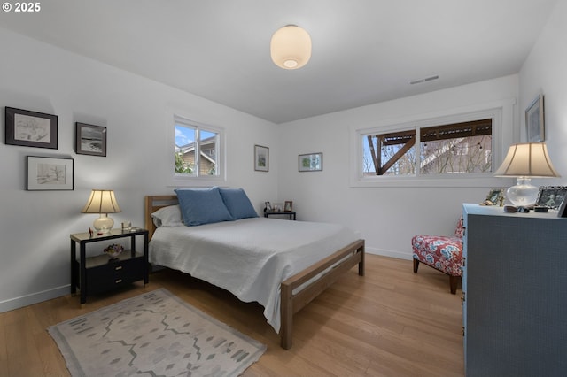 bedroom with visible vents, baseboards, and light wood-type flooring