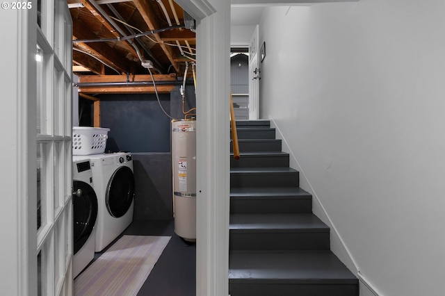 clothes washing area with laundry area, strapped water heater, and independent washer and dryer