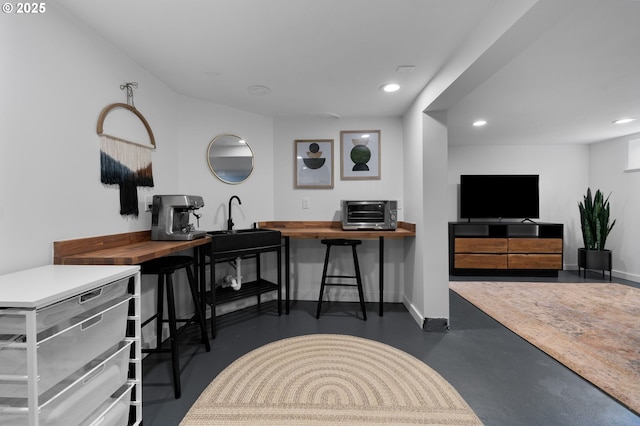 office space with recessed lighting, baseboards, finished concrete floors, and a toaster