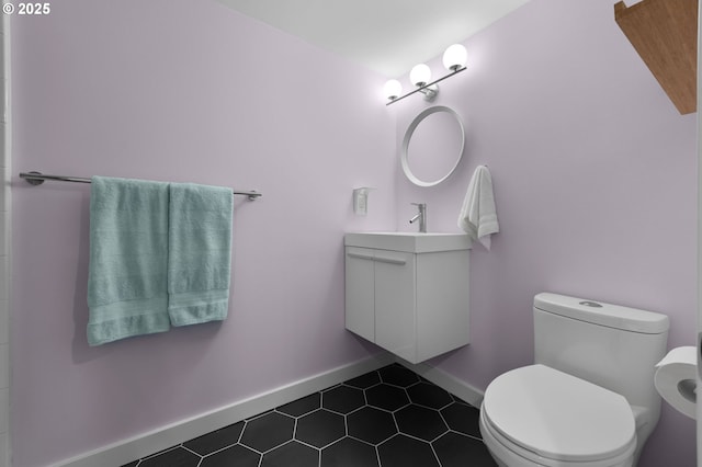 bathroom featuring tile patterned floors, toilet, vanity, and baseboards